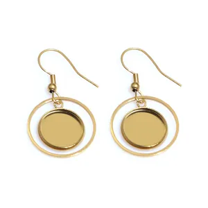 Macro detail of golden circular geometric earrings with hook design and polished finish
