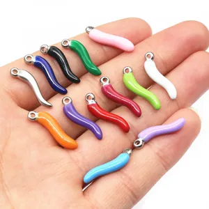 Colorful stainless steel chili pepper pendants held in hand for DIY jewelry making