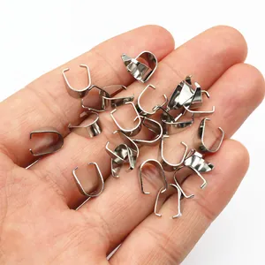 Polished stainless steel pinch bails for pendants held in a hand for size comparison