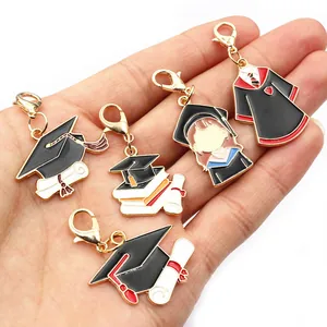 Five gold graduation charms with lobster clasps featuring mortarboards and gowns