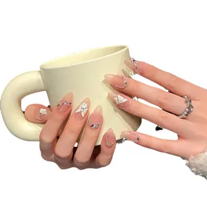 Unghie nude fatte a mano con farfalle 3D bianche, perle e strass su base rosa