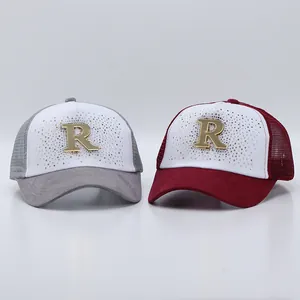 Dettaglio di cappellini con strass, logo R dorato e rete posteriore traspirante