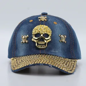 Detailed view of the golden skull emblem and rhinestones on the denim baseball cap