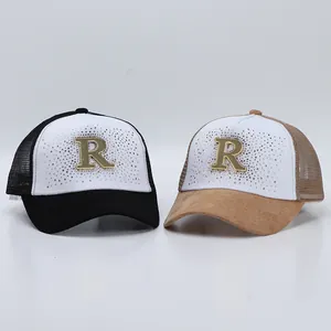 Dettaglio del logo R in strass su cappellini trucker in mesh traspirante neri e marroni