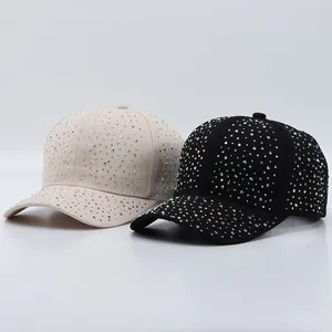 Détail de casquettes de baseball noires et beige avec strass colorés sur fond de studio