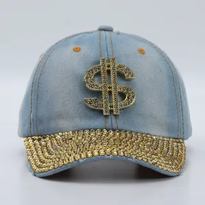 Detail of light blue denim baseball cap featuring a large gold rhinestone dollar sign