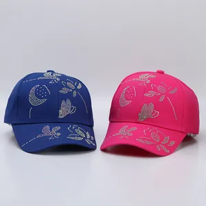 Detailed view of royal blue and rose red cotton baseball caps with butterfly rhinestone motifs
