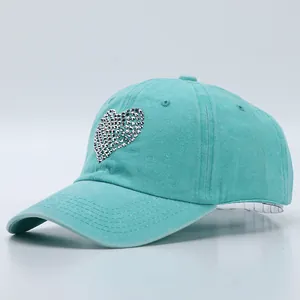 Detail of mint green washed cotton baseball cap featuring a sparkling rhinestone heart