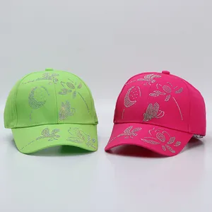 Detail of neon green and rose pink cotton baseball caps with sparkling rhinestone butterfly