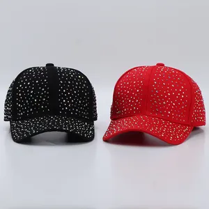 Gros plan sur des casquettes de baseball étincelantes en noir et rouge avec des strass