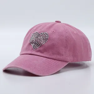 Detailed view of pink washed cotton baseball cap with silver rhinestone heart decoration