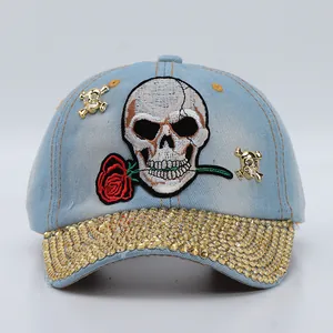 Detail view of denim baseball cap with skull embroidery and rhinestone brim