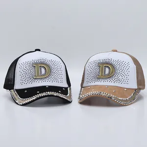 Dettaglio cappelli da baseball con strass, logo D metallico e rete traspirante