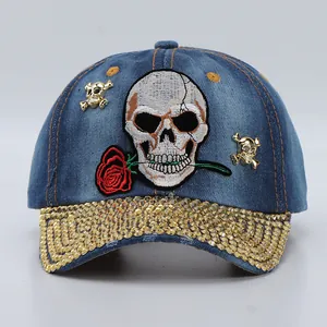 Detailed view of skull and rose embroidery with gold rhinestones on denim baseball cap