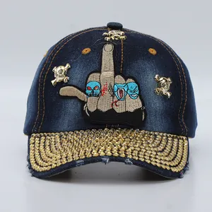 Close-up of denim baseball cap featuring skull coin motifs and studded rhinestone brim