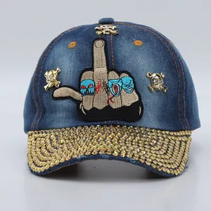 Detail of blue denim baseball cap with gold skull studs and rhinestones on the brim