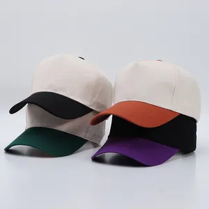 Detail view of cotton five-panel baseball caps showing multi-color brims and contrast stitching