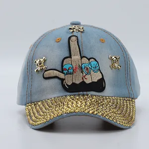 Close-up of denim baseball cap with rhinestone brim and skull embroidery details
