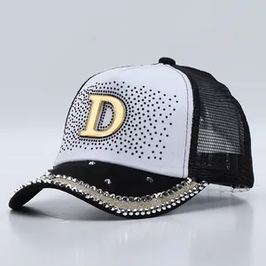 Dettaglio della lettera D dorata con strass e rete traspirante sul cappello