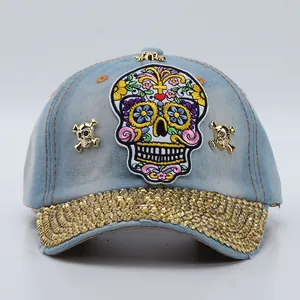Detail of light blue denim baseball cap with crystal brim and skull embroidery