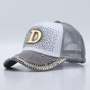 Dettaglio del cappello trucker con logo D in metallo, strass e rete posteriore traspirante