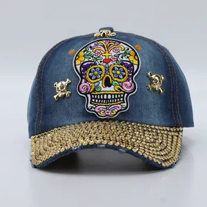 Detail of denim baseball cap featuring colorful sugar skull embroidery and gold rhinestones