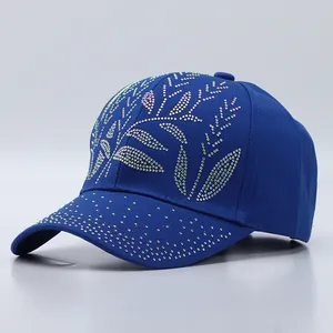 Detailed side view of a royal blue cotton baseball cap with sparkling rhinestone leaf patterns