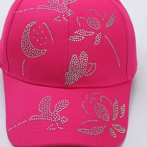 Detail of rose pink cotton baseball cap featuring intricate silver rhinestone butterfly patterns