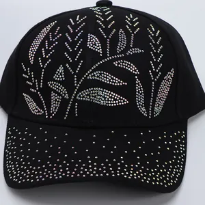 Close-up of vibrant iridescent rhinestones in leaf patterns on a black cotton baseball cap