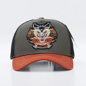 Close-up of premium wolf head embroidery and orange flame detail on a mesh trucker hat