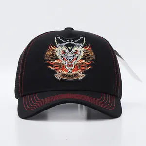Close-up of the wolf head embroidery and red contrast stitching on a black trucker cap