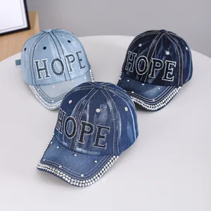 Close-up detail of three denim baseball caps featuring HOPE rhinestone letters and studs