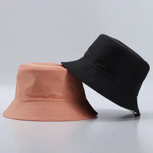 Close-up of black and pink bucket hats with multi-row reinforced stitching detail