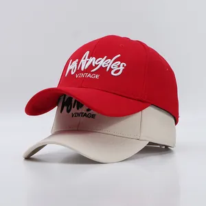 Detailaufnahme der 3D-Stickerei Los Angeles auf Baumwoll-Baseballkappen in Rot und Beige