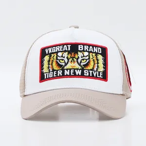 Detailed embroidery of a tiger eye patch on a white and khaki mesh trucker hat