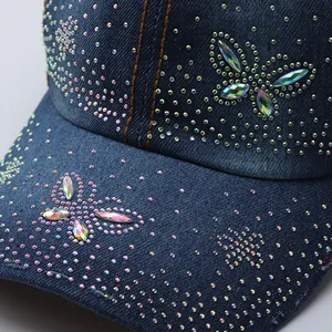 Close-up of sparkling rhinestone butterfly pattern on heavy denim baseball cap fabric