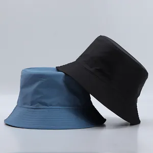 Close-up of blue and black bucket hats with reinforced stitched brims and canvas texture