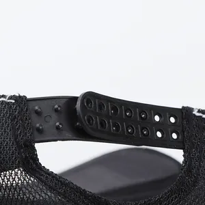 Close-up of adjustable double-row plastic snapback closure on a black mesh trucker cap