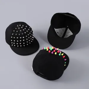 Detailed view of adjustable snapback closure and colorful punk rivets on black baseball caps