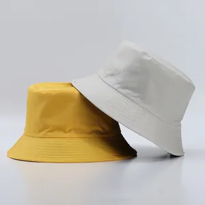 Close-up of simple bucket hats in yellow and grey with reinforced stitching on the brim