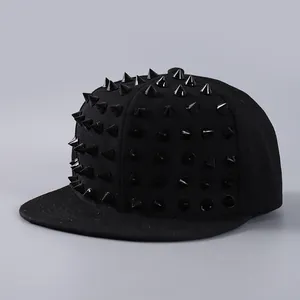 Close-up of black snapback hat with metallic cone studs in a punk streetwear style