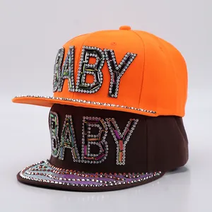 Detailed view of orange and brown hip hop caps with sparkling rhinestone BABY letters