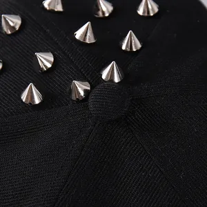 Detailed macro view of silver metallic cone studs on black twill fabric of the baseball cap