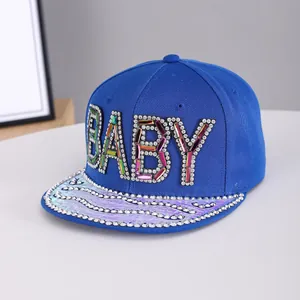 Detail of blue hip hop cap featuring sparkling rhinestone BABY letters and laser brim