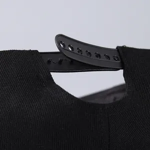 Close-up of the black snapback closure and twill fabric texture on a street style baseball cap