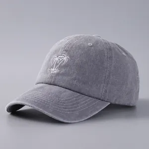 Detailed texture of charcoal grey washed cotton baseball cap with white coconut tree embroidery