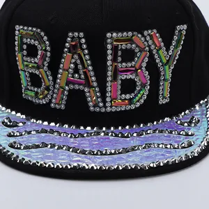 Detail of BABY lettering in colorful gemstones and silver studs on a flat brim baseball cap