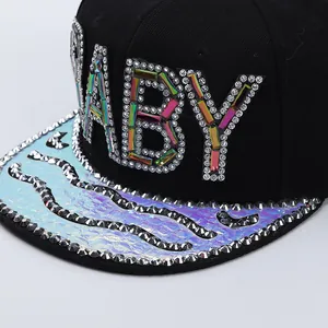 Close-up of sparkling BABY rhinestone letters and laser textured brim on black hip hop cap