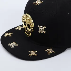Close-up of hip-hop snapback hat featuring gold skull studs and metal spikes on black fabric