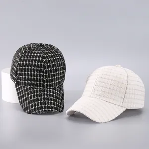 Close-up of black and white houndstooth baseball caps showing thick tweed fabric texture